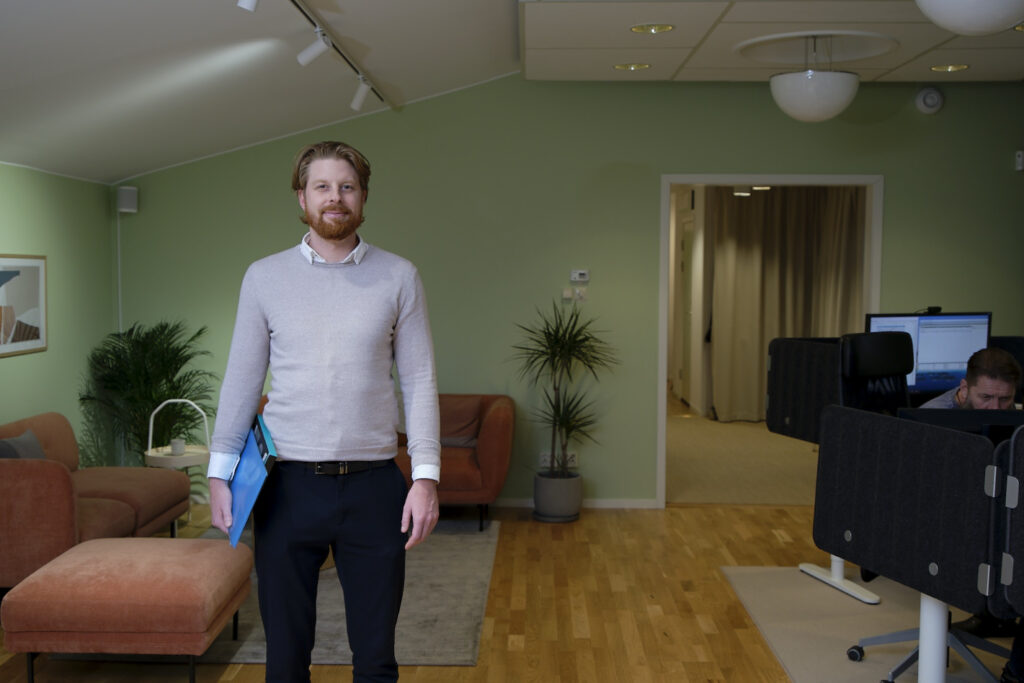 Medarbetare på Active IT går genom kontoret med dator under armen